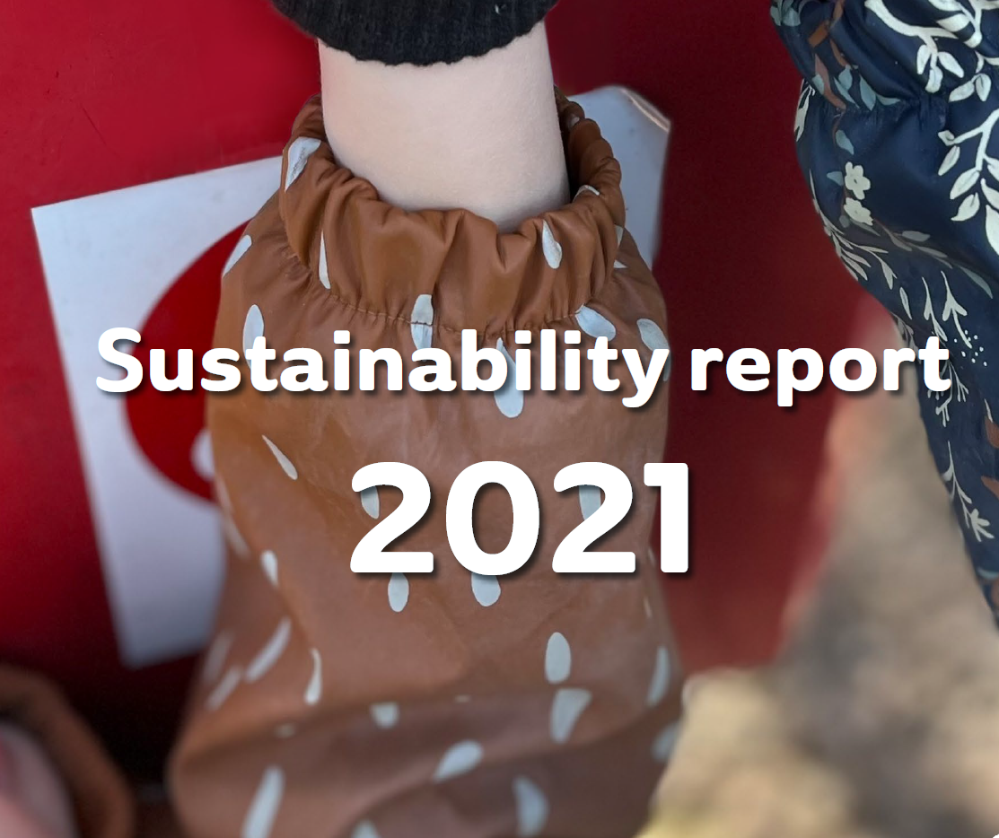 Cover image of the 2021 Sustainability Report, showing a child's hands putting batteries in El-Kretsen's red battery box