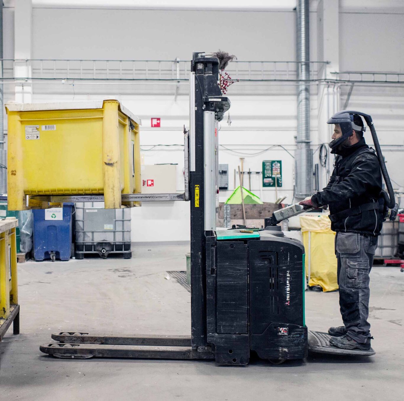 Återvinningspersonal lyfter en ljuskällebox